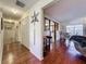 Hallway featuring gleaming hardwood floors, closet, and view of kitchen at 1617 E Sandpiper Trl, Casselberry, FL 32707