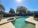 Backyard view featuring a sparkling swimming pool and spa under a sunny sky at 1617 E Sandpiper Trl, Casselberry, FL 32707