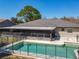 Rear exterior shot of sparkling pool, patio area and a fenced in yard; lush trees at 1617 E Sandpiper Trl, Casselberry, FL 32707