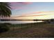 Backyard view showcasing the lake at sunset and iron fence at 16728 Bolsena Dr, Bella Collina, FL 34756