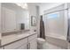 Pristine white bathroom with gray accents, featuring a shower-tub combo, and sleek fixtures at 16728 Bolsena Dr, Bella Collina, FL 34756