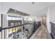 Open hallway showcasing wood floors, modern railing, and views into the living room below at 16728 Bolsena Dr, Bella Collina, FL 34756