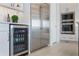 Modern kitchen boasts stainless steel appliances, including a refrigerator and wine cooler at 16728 Bolsena Dr, Bella Collina, FL 34756