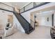 Grand foyer showcasing a black staircase with metal railings and light neutral-toned flooring at 16728 Bolsena Dr, Bella Collina, FL 34756