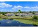 Aerial view of the property with a scenic pond, showcasing a serene community and well-maintained homes at 17319 Million Lakes Ct, Clermont, FL 34714