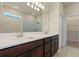 Elegant bathroom with double vanity, granite countertop, large mirror, and glass-enclosed shower for a luxurious feel at 17319 Million Lakes Ct, Clermont, FL 34714