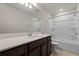 Bathroom with a shower over tub and dark wood vanity with white countertop at 17319 Million Lakes Ct, Clermont, FL 34714