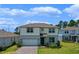 Charming two-story home featuring a manicured lawn and brick driveway at 17319 Million Lakes Ct, Clermont, FL 34714