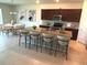 Modern kitchen with an island, dark cabinets, stainless steel appliances, and an adjacent dining area at 17319 Million Lakes Ct, Clermont, FL 34714