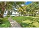 Lush backyard with mature trees, a walkway, and a waterfront view with a private dock at 1840 W Fawsett Rd, Winter Park, FL 32789