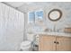 Stylish bathroom featuring decorative wallpaper, a round mirror, and a wood vanity at 1840 W Fawsett Rd, Winter Park, FL 32789