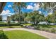 Expansive front yard with a lush lawn, mature trees, and a paver driveway leading to the home at 1840 W Fawsett Rd, Winter Park, FL 32789