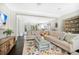 Bright living room featuring a floral rug, large sectional sofa, and open access to the kitchen at 1840 W Fawsett Rd, Winter Park, FL 32789