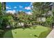 Backyard putting green for leisurely practice, surrounded by lush landscaping and mature trees at 1840 W Fawsett Rd, Winter Park, FL 32789