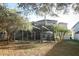 View of the screened pool and patio area, nestled in the spacious backyard with mature trees at 1924 Stonecrest Ct, Orlando, FL 32825