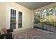 Outdoor balcony includes two chairs and a glass table overlooking a wooded area at 1924 Stonecrest Ct, Orlando, FL 32825