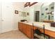 Bathroom featuring wood cabinets, long countertop, and a large framed mirror at 1924 Stonecrest Ct, Orlando, FL 32825