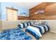 Bright bedroom with two twin beds, wood accent wall, blue walls, and a blue rug at 1924 Stonecrest Ct, Orlando, FL 32825