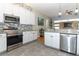 Modern kitchen with granite countertops, stainless steel appliances, white cabinets, and decorative tile backsplash at 1924 Stonecrest Ct, Orlando, FL 32825