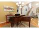 Formal room with vintage piano, unique accent wall, hardwood flooring, staircase, and modern light fixture at 1924 Stonecrest Ct, Orlando, FL 32825