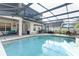 Inviting covered pool featuring dining and lounge area with beautiful views of the yard and home at 1924 Stonecrest Ct, Orlando, FL 32825