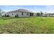 Lush green backyard featuring a well-maintained lawn and the home's exterior at 19301 Wembley Ave, Orlando, FL 32833