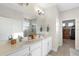 Bright bathroom featuring a double sink vanity with quartz countertop and tiled floors, and a shower with glass door at 19301 Wembley Ave, Orlando, FL 32833