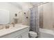 Well-lit bathroom with a single vanity, shower and tub with patterned curtain, and decorative wall art at 19301 Wembley Ave, Orlando, FL 32833