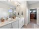 Bright bathroom featuring a double sink vanity with quartz countertop and tiled floors, and a shower with glass door at 19301 Wembley Ave, Orlando, FL 32833