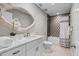 Well-lit bathroom with a modern vanity, decorative mirror, and a shower-tub combo at 230 S Ranger Blvd, Winter Park, FL 32792