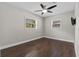 Well-lit bedroom featuring hardwood floors, ceiling fan, and two windows at 230 S Ranger Blvd, Winter Park, FL 32792