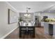 A formal dining room is adorned with a chandelier, contemporary artwork, and rich hardwood flooring at 230 S Ranger Blvd, Winter Park, FL 32792