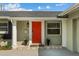 A charming front porch is adorned with a bright red door and manicured landscaping at 230 S Ranger Blvd, Winter Park, FL 32792