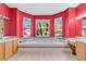 A vibrant bathroom with a large tub, dual vanities, bright red walls, and natural light from multiple windows at 2509 Chapala Dr, Kissimmee, FL 34746