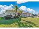 Well-maintained home featuring mature palm trees, green lawn, and a three-car garage at 2509 Chapala Dr, Kissimmee, FL 34746