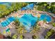 Stunning aerial view of the community pool area with palm trees, slides, and lounge chairs at 2774 Almaton Loop # 101, Kissimmee, FL 34747