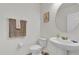 Bright powder room featuring pedestal sink, decorative mirror, and Eiffel Tower motif at 3179 Turret Dr, Kissimmee, FL 34743