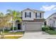 Charming two-story home featuring a well-manicured lawn, palm tree, and a two car garage at 3179 Turret Dr, Kissimmee, FL 34743