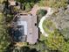 An aerial shot exhibits a home with a pool, patio area, and a circular driveway surrounded by lush greenery at 3431 Dawn Ct, Lake Mary, FL 32746