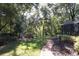 Tranquil backyard brick path leads to a seating area nestled among mature trees at 3431 Dawn Ct, Lake Mary, FL 32746