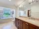 Bathroom featuring dual sink vanity, large mirror, and bright window views at 3431 Dawn Ct, Lake Mary, FL 32746