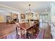 Elegant dining room featuring a wood table, chandelier, and views into the kitchen and stone fireplace living room at 3431 Dawn Ct, Lake Mary, FL 32746