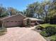 Charming home exterior with a brick driveway, beautiful gardens, and mature trees at 3431 Dawn Ct, Lake Mary, FL 32746