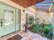 Charming front entrance featuring a sage-green door, stone accents, decorative fountain, and lush landscaping at 3431 Dawn Ct, Lake Mary, FL 32746