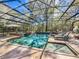 Screened in pool with hot tub, lush landscaping, and lounge chairs at 3431 Dawn Ct, Lake Mary, FL 32746