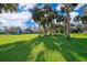 Lush green lawn with a view of the home and mature palm trees at 372 Rest Haven Rd, Geneva, FL 32732