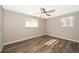 Neutral bedroom with wood-look floors, ceiling fan, and natural light from two windows at 372 Rest Haven Rd, Geneva, FL 32732