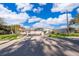 Gated entry to a grey house featuring a screened in pool with lush lawns at 372 Rest Haven Rd, Geneva, FL 32732