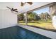 Enclosed patio features tile flooring and a panoramic view of the lush backyard at 372 Rest Haven Rd, Geneva, FL 32732