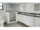 Modern bathroom with a glass-enclosed shower, granite countertop, and double vanity at 5030 Creekview Ln, Lakeland, FL 33811